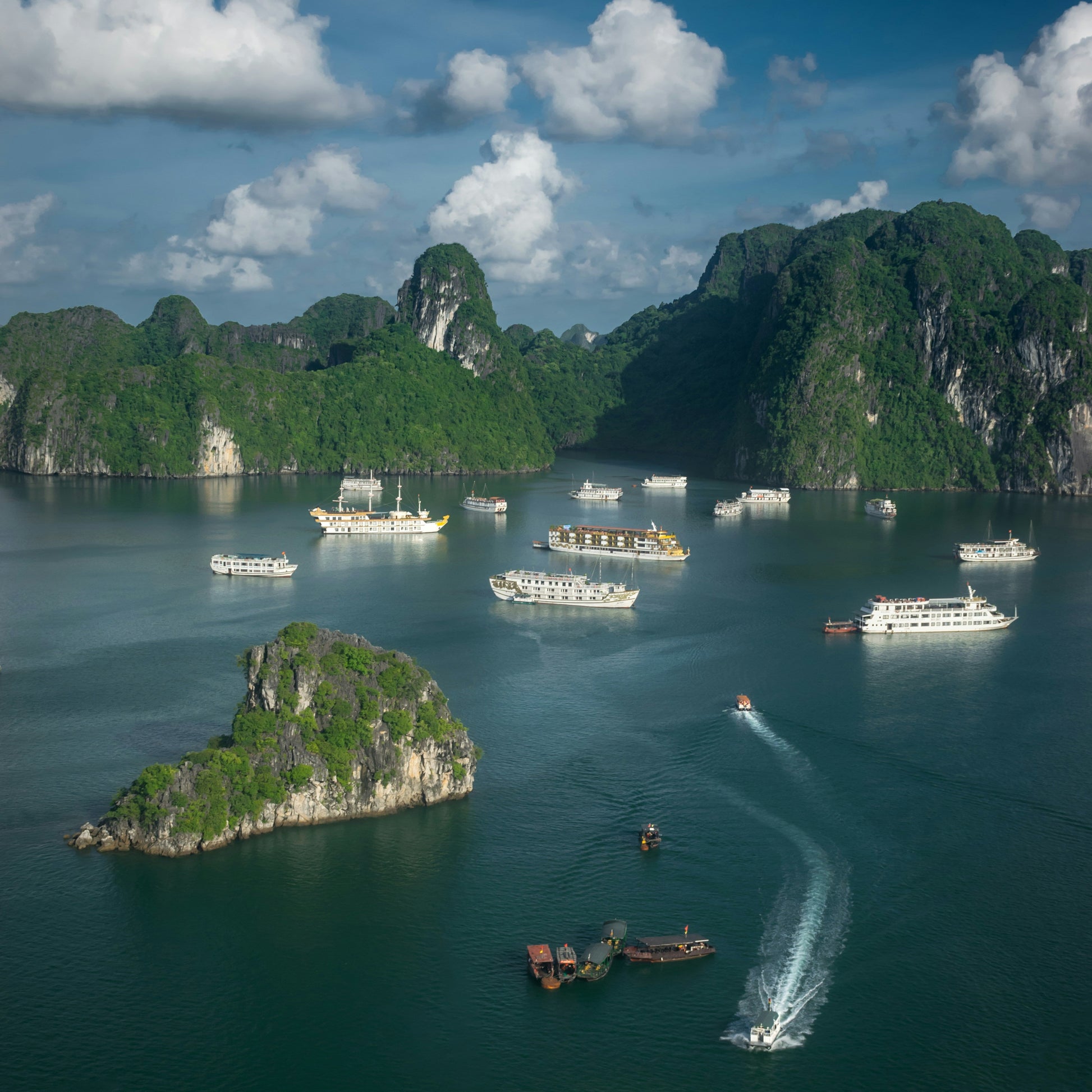  Traditional boats sailing through the limestone islands of Ha Long Bay, a UNESCO site covered by our reliable Vietnam travel eSIM.